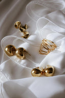 Various 18k gold plated earrings flatter on the white silk to show their shine