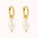 Minimalist gold-plated twisted hoop earrings with pearl pendant on light beige background by verosteel jewelry 