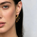 a model show her ear wearing 18k gold plated triple wing earrings