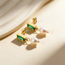 18k gold plated earrings with emerald with pearl drop styled on beige background