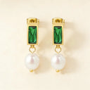 Close-up of stainless steel earrings with emerald with pearl showing the design and texture