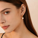 Model styling 18k gold plated earrings with soft lighting