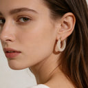 Model showcases the pearl drop earrings on one side's ear