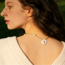 model wearing plum blossom pendant necklace on her back  in natural lighting 