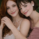 two models sitting together  to showcase the bracelet at the front with blurry necklace on the back