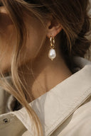 side of ear to showcasing model wearing a gold plated earrings from vero steel jewelry 