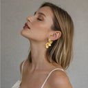 Model slightly turned wearing  stainless steel statement earrings